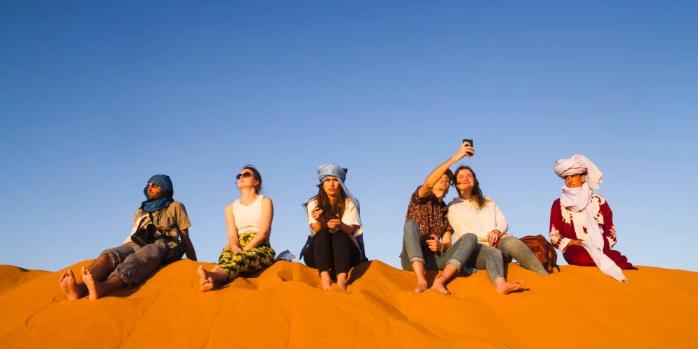 A group of people sitting during desert safari Abu Dhabi tours
